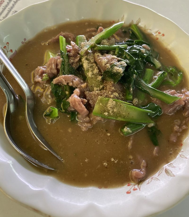 เนื้อกับผักคะน้าในน้ำราดข้นสีน้ำตาล โรยพริกไทย